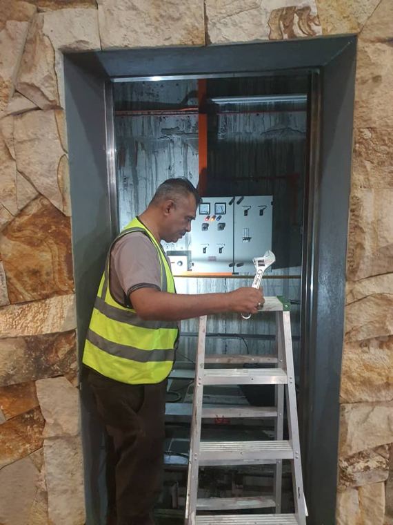 Juruteknik Wan Power Tech memeriksa panel kawalan lif