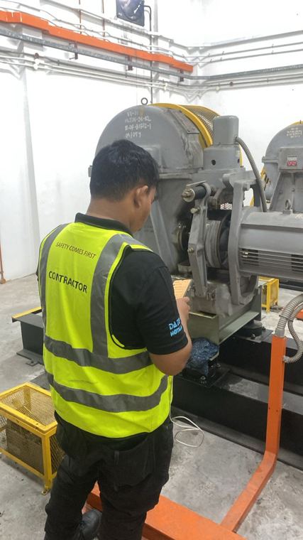 Juruteknik memeriksa mesin tarikan di bilik mesin